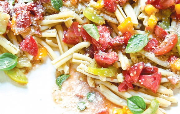 uncooked marinated tomatoes over pasta